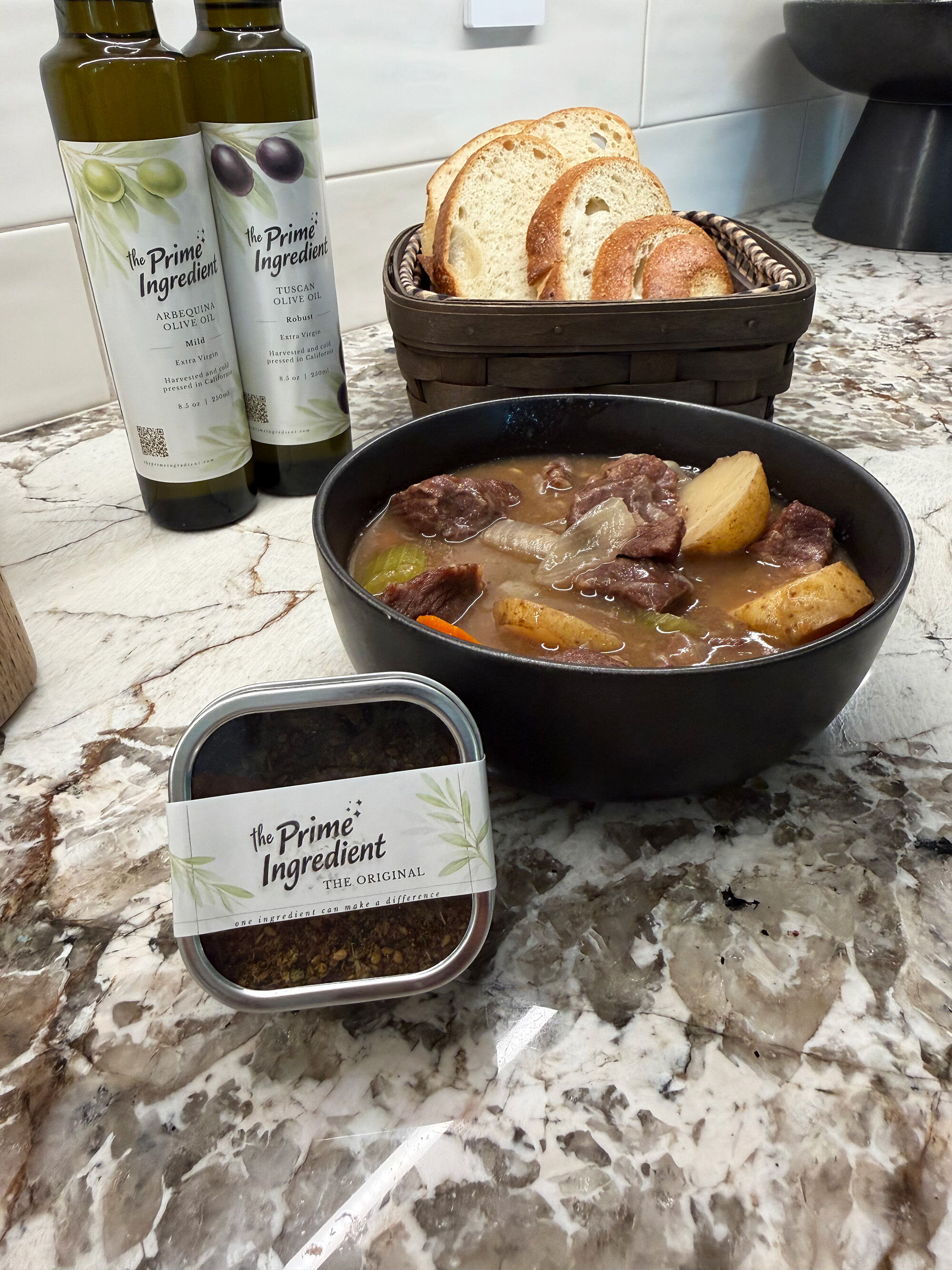 A bowl of stew with bread, spices, and olive oil.